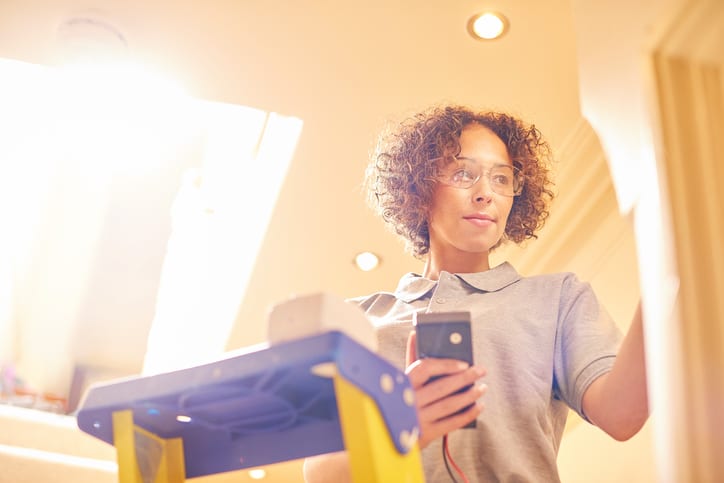 Palmetto Electrical Contractors | female electrician fitting a sensor in a hallway